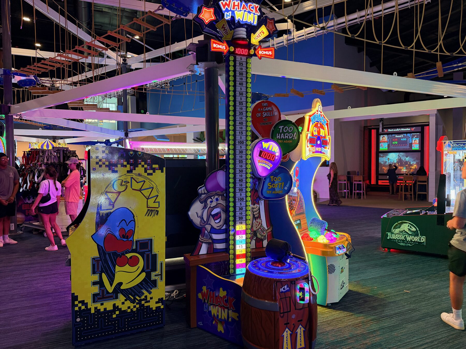 Colorful arcade games beneath the indoor ropes course at High Tides
