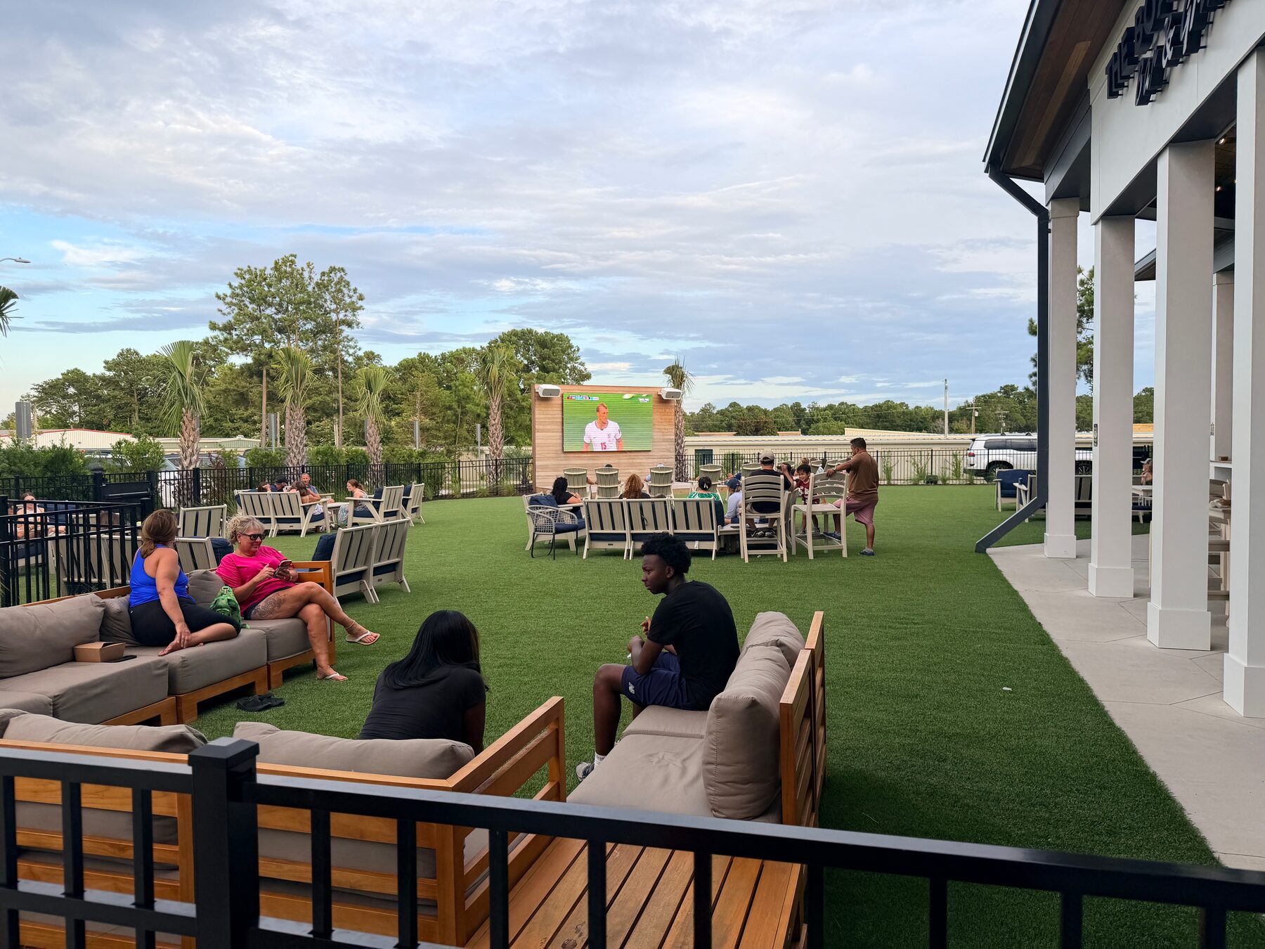 Outdoor beer garden, lawn, seating, and large screen at High Tides & Good Vibes