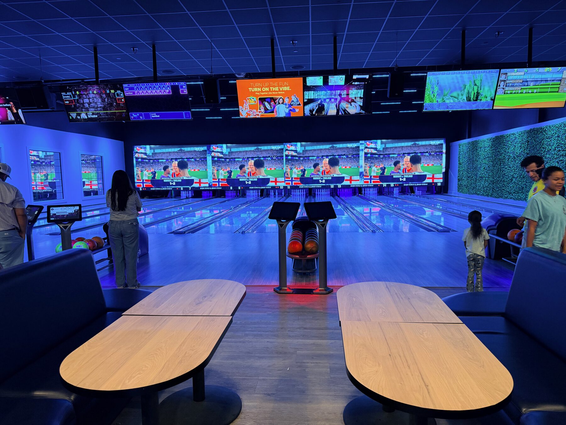 Premium bowling lanes with comfortable seating and a wall-sized video display at High Tides & Good Vibes in Surf City