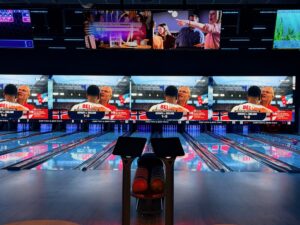 Premium bowling lanes and wall-sized sports video display at High Tides & Good Vibes in Surf City