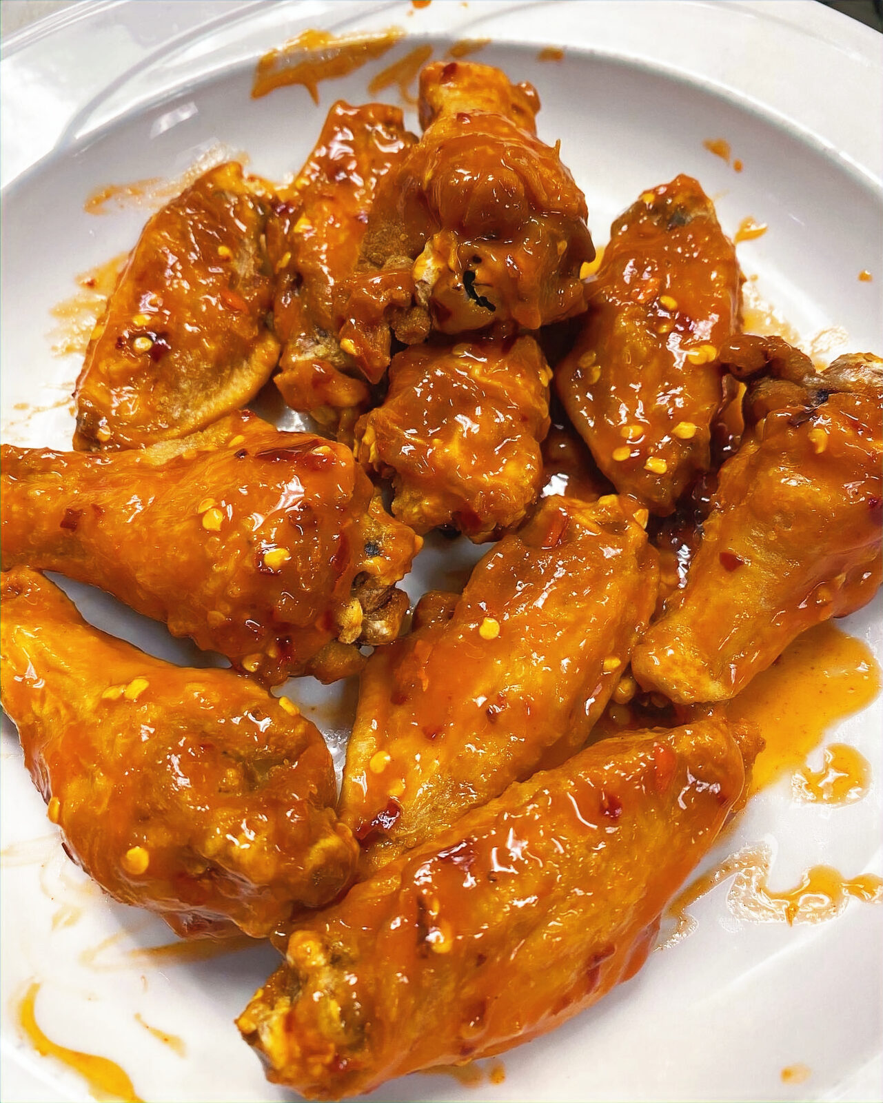 A plate of saucy chicken wings at Baked Pizza Company