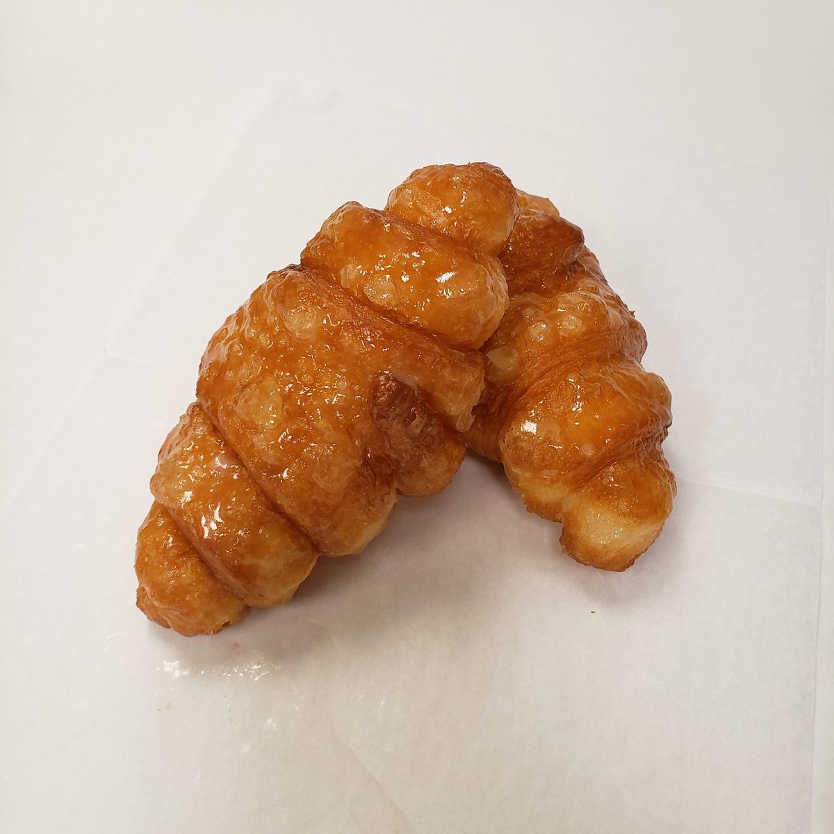A glossy glazed fried croissant from Burney’s Sweets & More