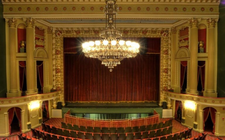 The gilded main stage and chandelier at Thalian Hall
