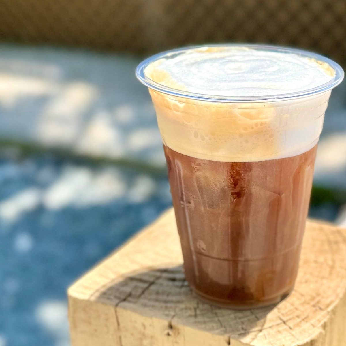 An iced coffee topped with cold foam outside The Daily Grind