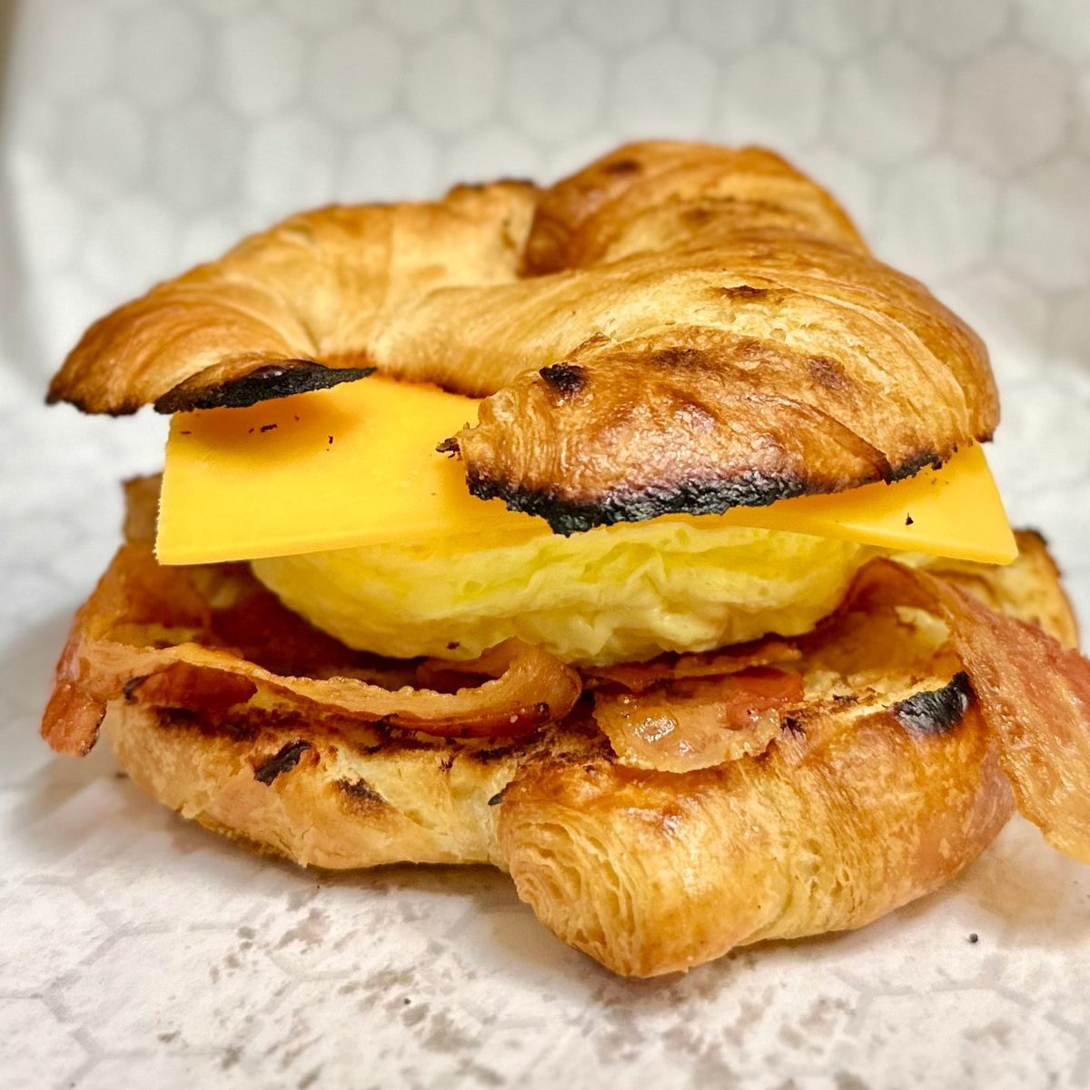 A croissant breakfast sandwich with egg, cheese and bacon