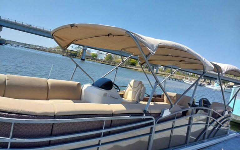 A rental tritoon at the dock with the Surf City bridge behind