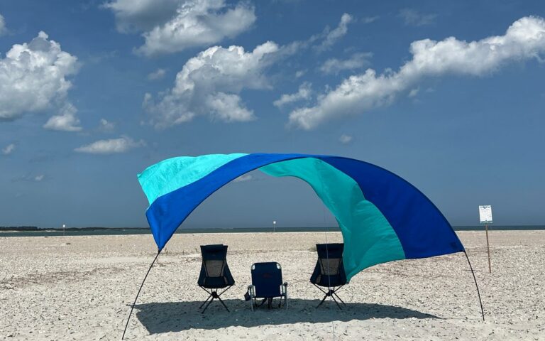 A shade and chairs set up on a sandbar