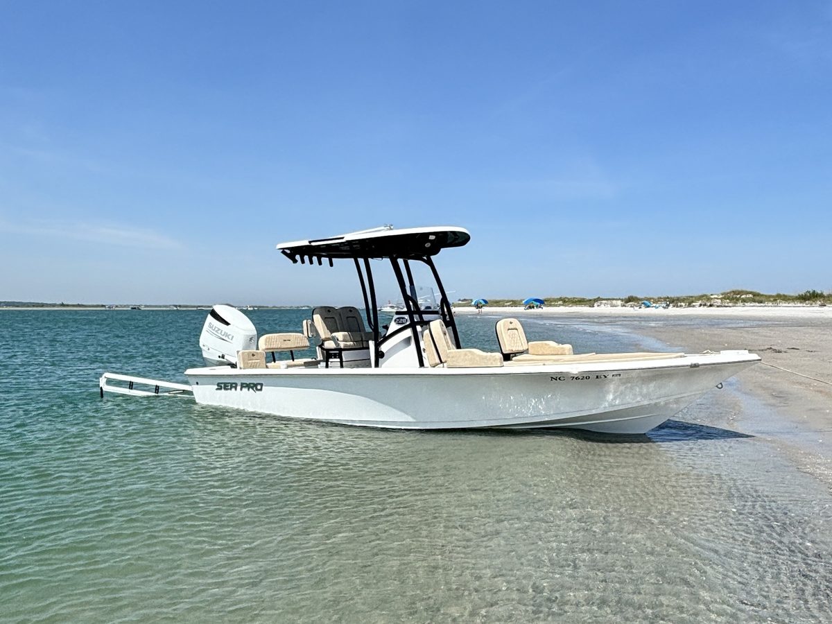 A charter boat beached on a clear sandbar