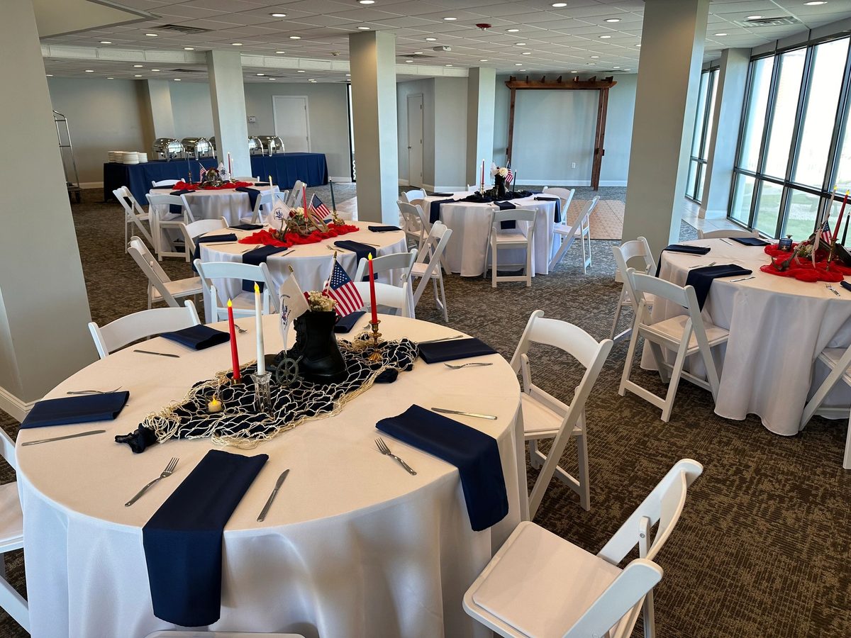 Round tables with white cloths in an ocean-view hall