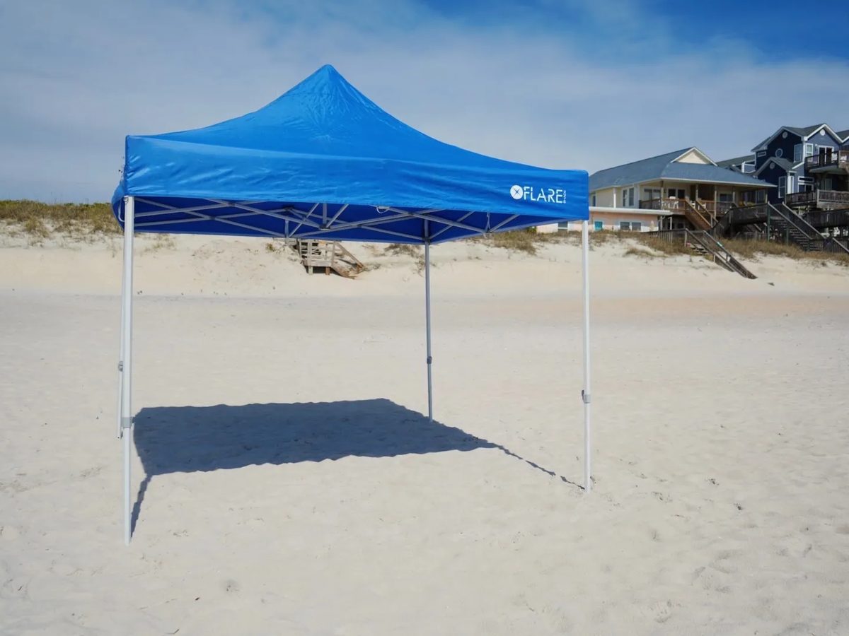 An empty canopy on a wide beach with oceanfront homes