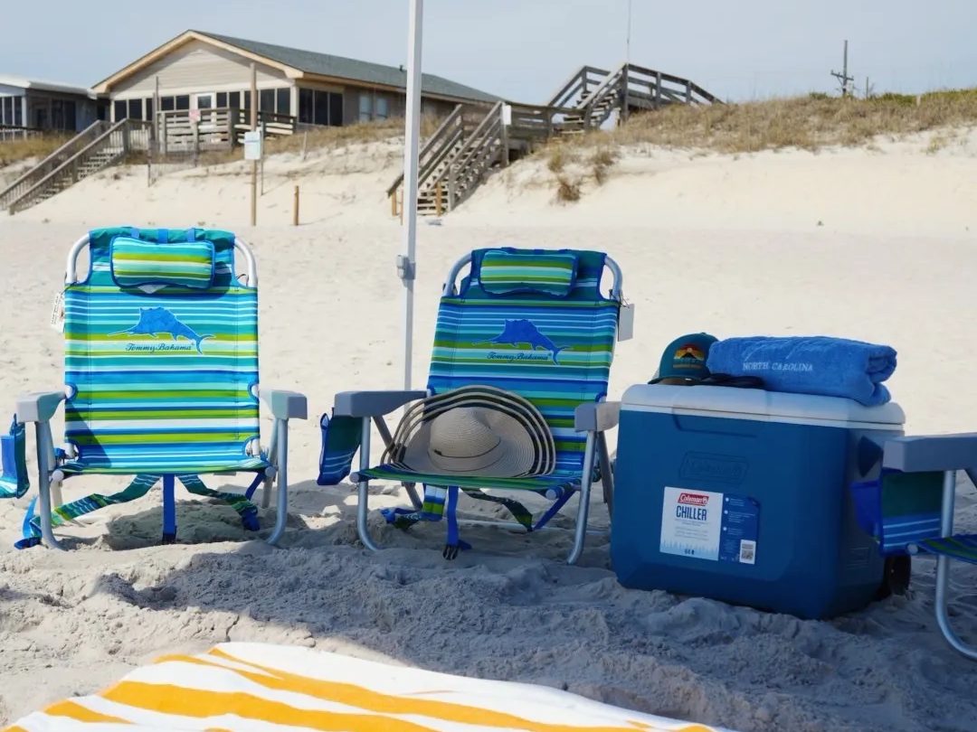 Chairs, a cooler and a towel under the canopy