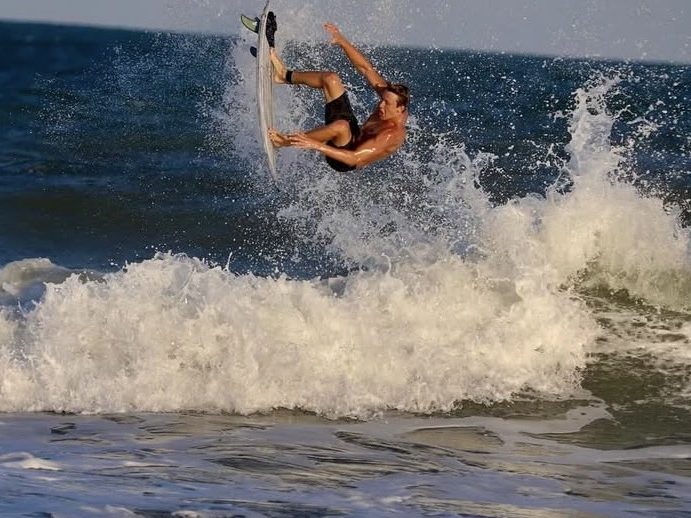 A surfer in the air above a wave
