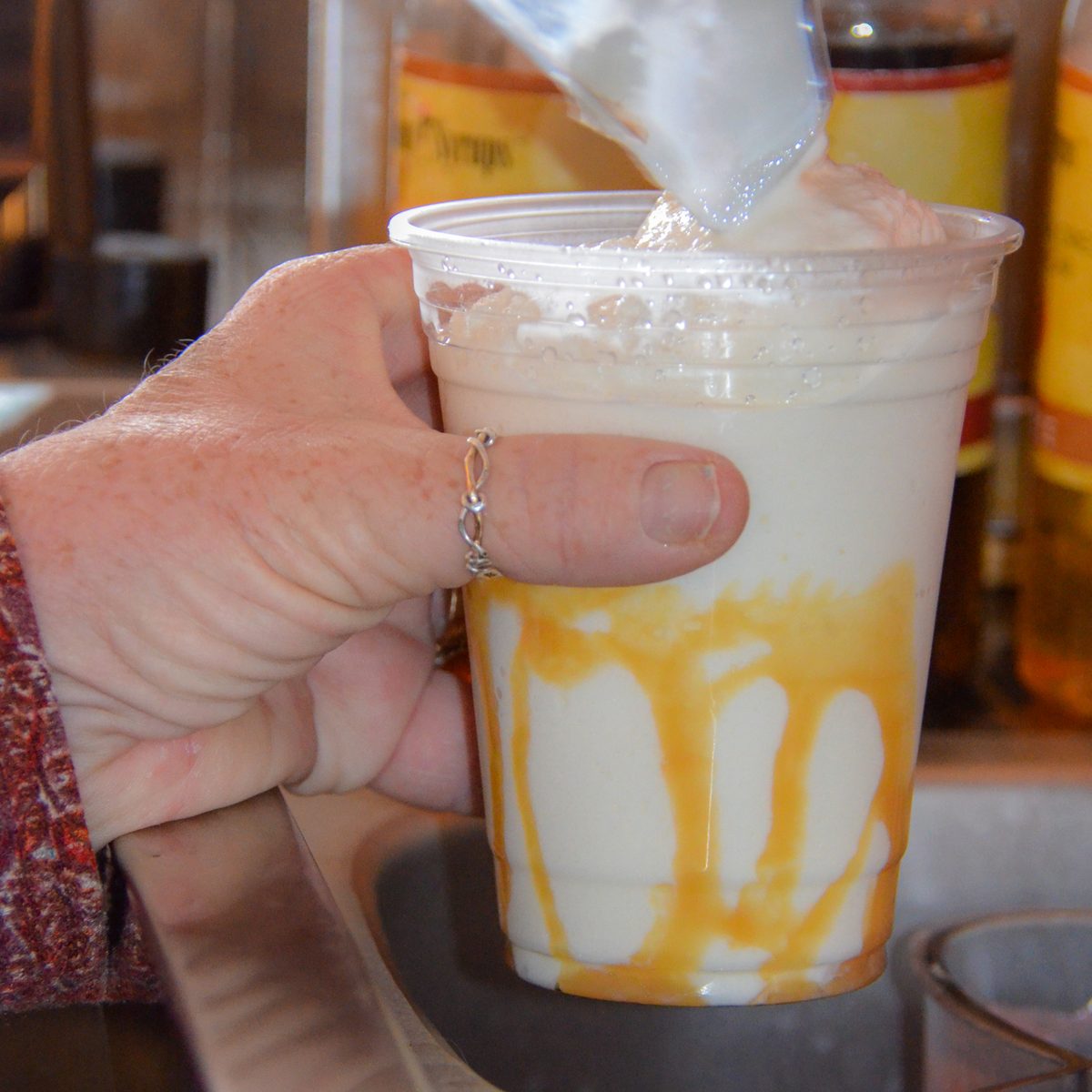 A frappe poured into a caramel-drizzled cup at Surf City Coffee