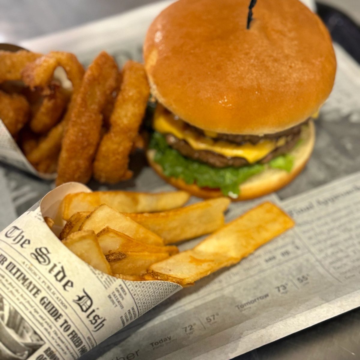 A double cheeseburger with onion rings and fries from Sweet Island