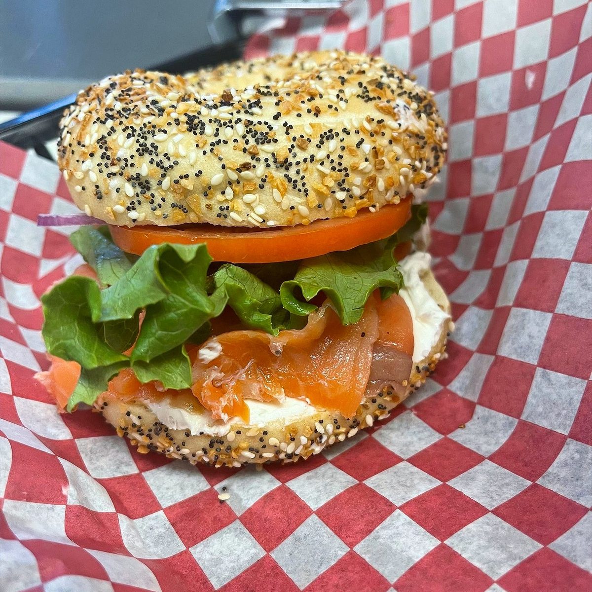 An everything bagel with cream cheese, smoked salmon, lettuce and tomato